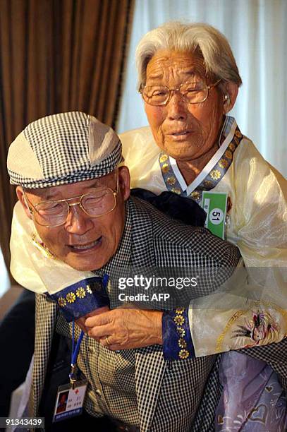 South Korean Yang Yoon-Hak carries his North Korean older sister his the back as they bid farewell following their three-day family reunion at the...