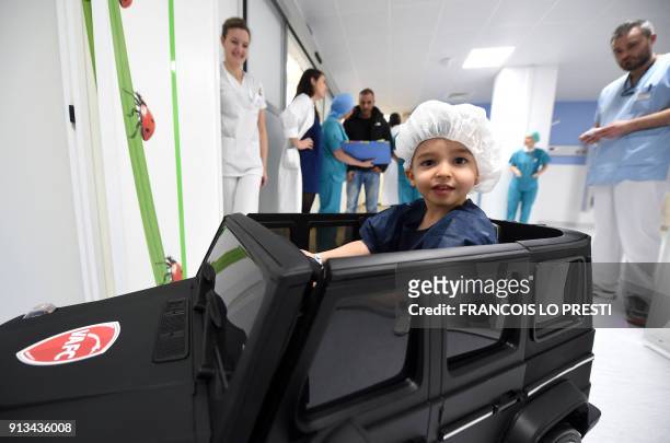 Medical staff watch as two-year-old Souhail sitting in an electric toy car goes to the operating room at the Valenciennes Hospital in Valenciennes,...