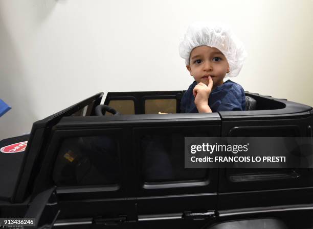 Two-year-old Souhail sits in an electric toy car on his way to the operating room at the Valenciennes Hospital in Valenciennes, northern France, on...