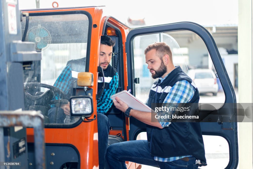 Workers in warehouse with forklift