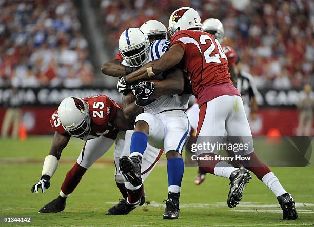 Joseph Addai of the Indianapolis Colts is tackled by Gerald Hayes, Bryant McFadden and Adrian Wilson of the Arizona Cardinals during the game at...