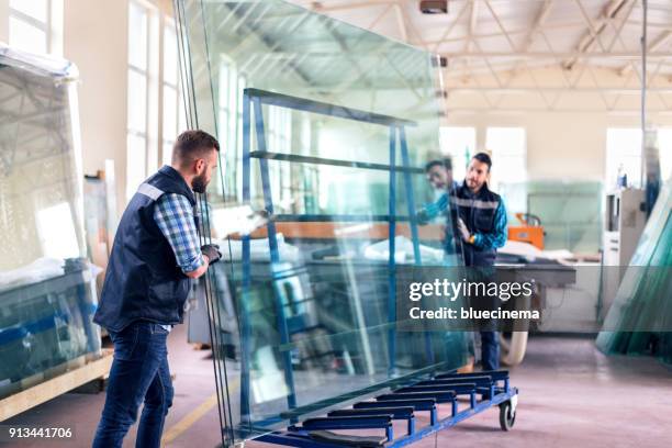werknemers verpakking glazen bladen in magazijn - glas stockfoto's en -beelden