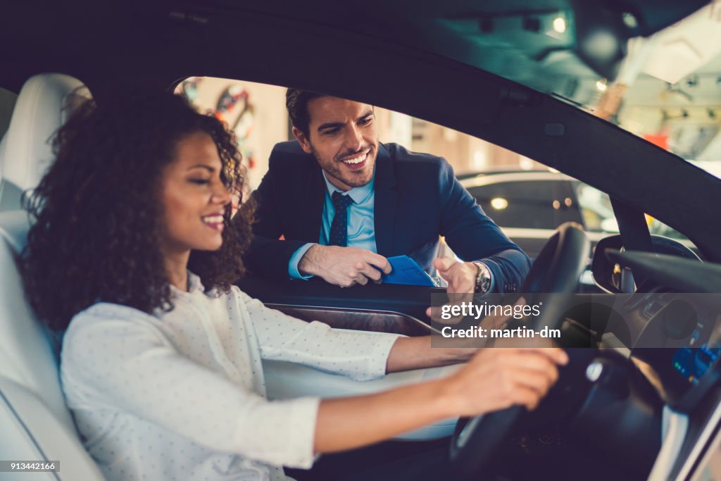 Gemengd ras vrouw genieten van nieuwe auto