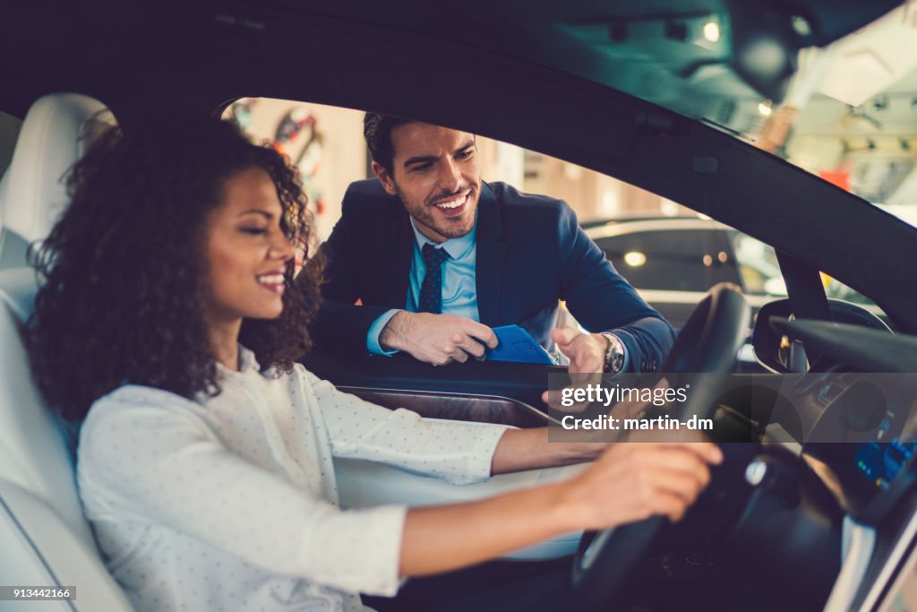 Mixed race woman enjoying new car