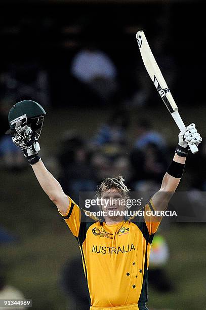 Australian batsman Shane Watson raises his bat and helmet as he celebrates scoring a century 100 runs during the ICC Champions Trophy semi final...