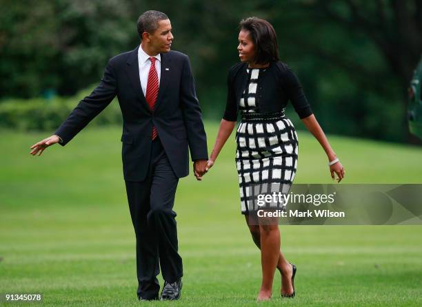 President Barack Obama and his wife first lady Michelle Obama walk on the south lawn after arriving back at the White House on October 2, 2009 in...