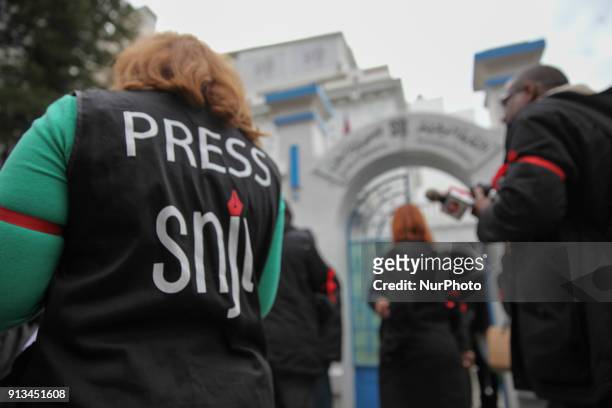Tunisian journalists wear red ribbons around their arms during a demonstration held under the slogan Tunisian press in anger, outside the headquarter...