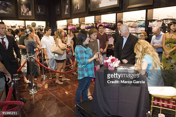 Marisa Miller signs photos during an autograph session during the grand opening of Hawaii's first ever Victoria's Secret store at Ala Moana Center on...