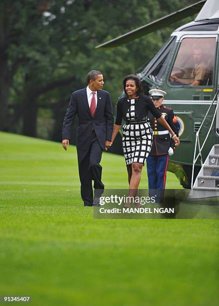 President Barack Obama and First Lady Michelle Obama make their way from Marine One October 2, 2009 upon return to the White House in Washington, DC....