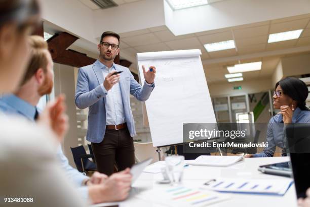 hombre de negocios que presenta el nuevo proyecto a los socios en la oficina - show business fotografías e imágenes de stock