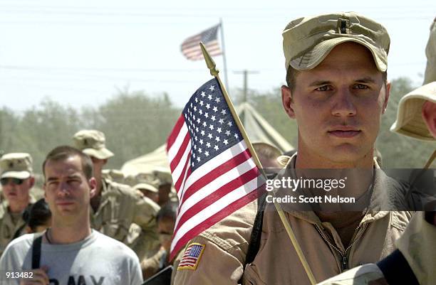 Army 1st Lt. Joe Odorizzi from Staunton, Illinois waits in line with other soldiers for a barbecue at Bagram airbase July 4, 2002 in Afghanistan....