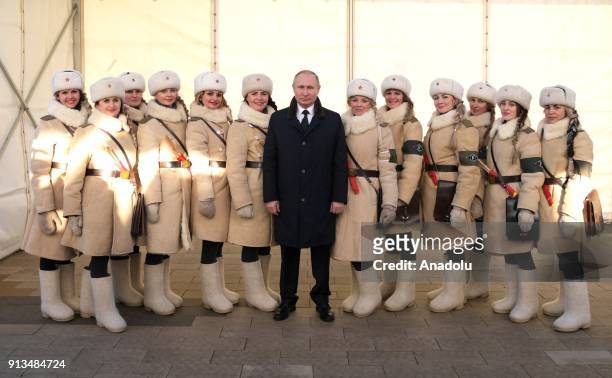 Russian President Vladimir Putin poses for a photo with girls dressed in Soviet WWII uniforms of traffic control officers as he attends the Names...