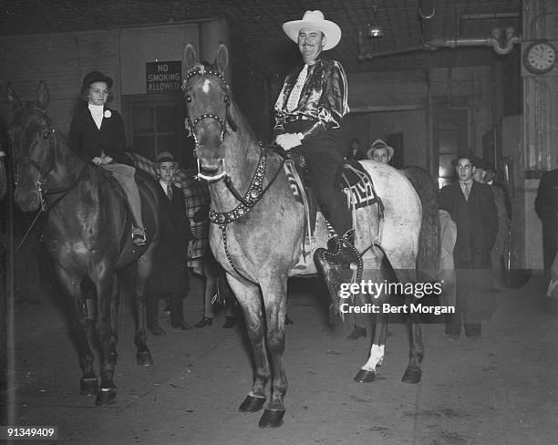 Orchestra leader Paul Whiteman with his horse Walkalong at the Riding and Polo Club Horse Show in New York City, c1935. His daughter Margo is on the...