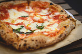 Close up view of a Margherita Neapolitan style pizza with buffalo mozzarella, tomato sauce and basil.