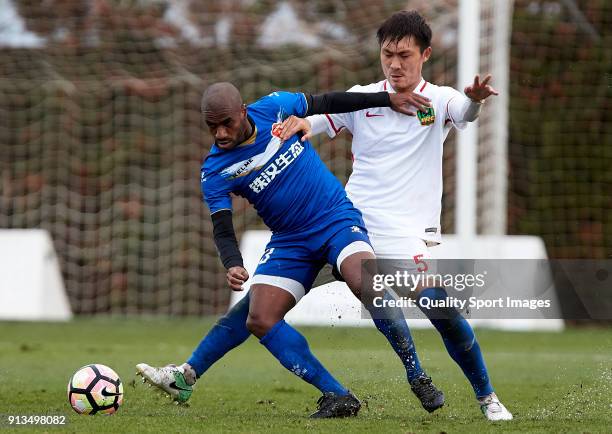 Lin Longchang Guizhou Henfeng Zicheng competes for the ball with Luiz Muriqui of Meizhou Meixian during the friendly match between Guizhou Henfeng...