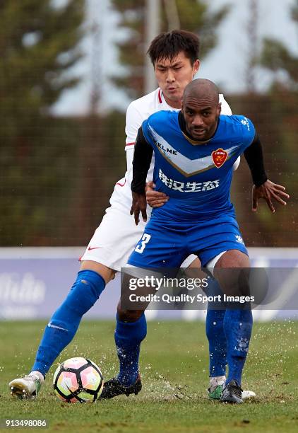 Lin Longchang Guizhou Henfeng Zicheng competes for the ball with Luiz Muriqui of Meizhou Meixian during the friendly match between Guizhou Henfeng...