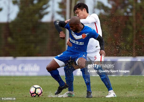 Lin Longchang Guizhou Henfeng Zicheng competes for the ball with Luiz Muriqui of Meizhou Meixian during the friendly match between Guizhou Henfeng...