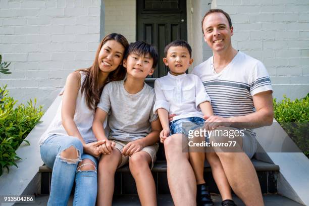 portrait of young family in front of the house - australásia imagens e fotografias de stock