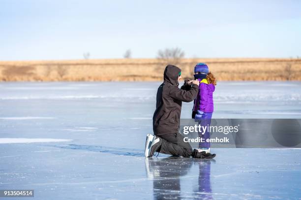 vater helfende tochter anpassen schal beim eislaufen - figure skating day 7 stock-fotos und bilder