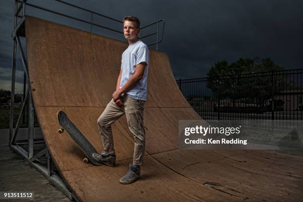 teenage boy posing with skateboard on half pipe - boy skatepark stock-fotos und bilder