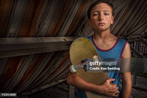 teen skate boarder holding his board - ken redding fotografías e imágenes de stock