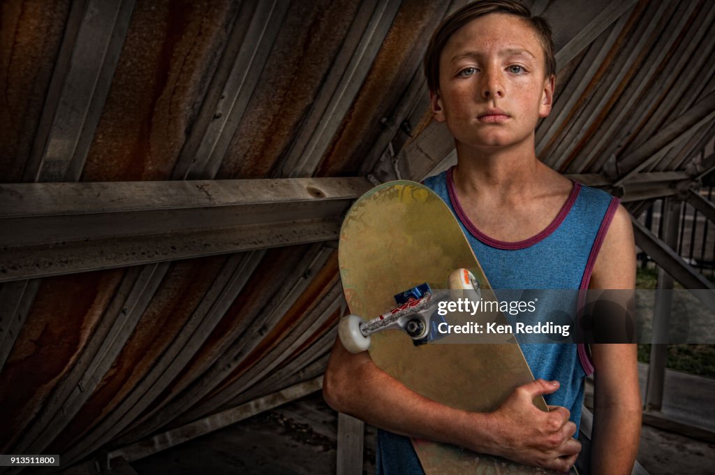 Teen Skate Boarder holding his board