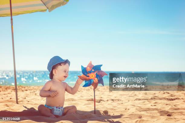 baby met speelgoed pinwheel - baby sommer stockfoto's en -beelden
