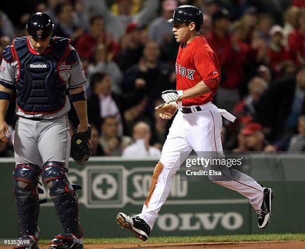 Jacoby Ellsbury of the Boston Red Sox scores a run in the first inning as Kelly Shoppach of the Cleveland Indians stands by on October 2, 2009 at...