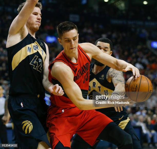 Toronto Raptors center Jakob Poeltl and Toronto Raptors guard Fred VanVleet combine to defend adjacent Portland Trail Blazers center Zach Collins ....
