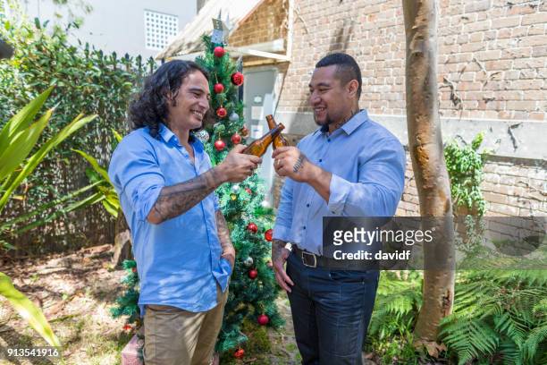 pacific islander men making a celebratory toast at a christmas party - sydney christmas lights 2017 stock pictures, royalty-free photos & images