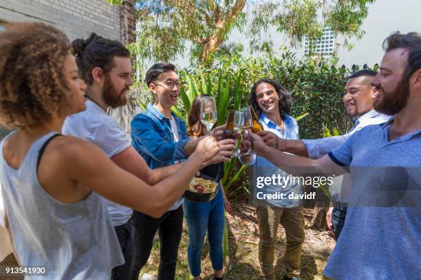 group of mixed race people making a celebratory toast at a christmas party - sydney christmas lights 2017 stock pictures, royalty-free photos & images