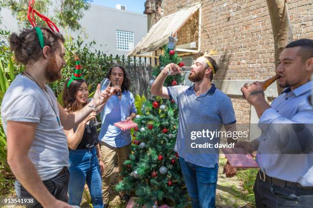 group of mixed race people making a celebratory toast at a christmas party - sydney christmas lights 2017 stock pictures, royalty-free photos & images