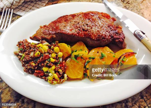 pan fried, grass-fed sirloin steak ,with golden beets and a heirloom tomato, sweet corn quinoa salad - golden beet stock pictures, royalty-free photos & images
