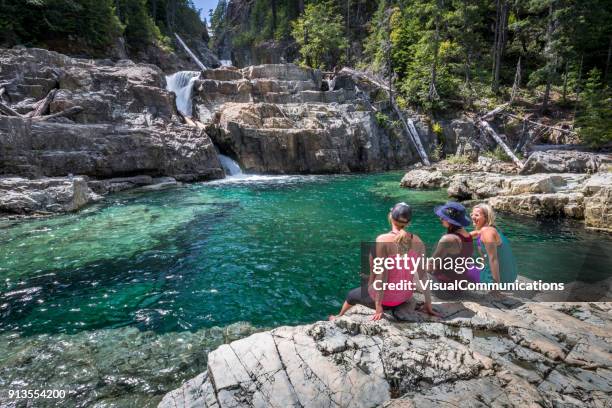 group of friends resting by waterfalls. - three people sitting stock pictures, royalty-free photos & images