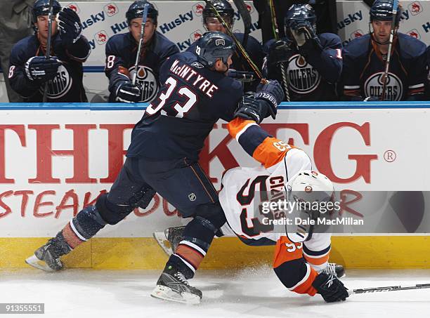 Steve MacIntyre of the Edmonton Oilers checks Casey Cizikas of the New York Islanders to the ice on September 16, 2009 at Rexall Place in Edmonton,...