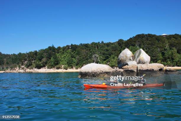 kayakers in gehuurde kajak peddel rond split apple rock, able tasman nationaal park tasman regio, nieuw-zeeland - kaiteriteri stockfoto's en -beelden