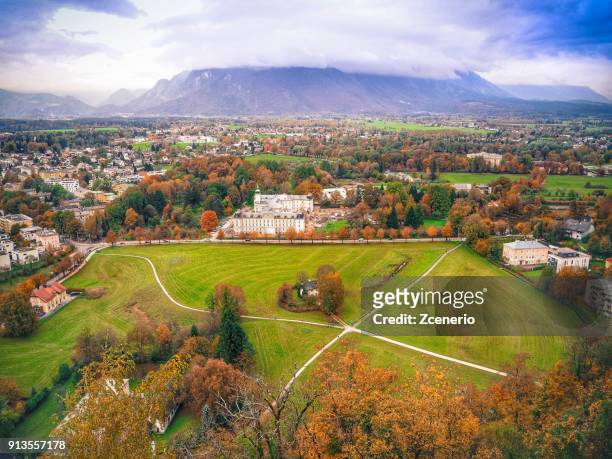 a local house at the middle of green field from aerial view on the roof of hohensalzburg fortress in the city of salzburg, austria during autumn - giardini di mirabell foto e immagini stock