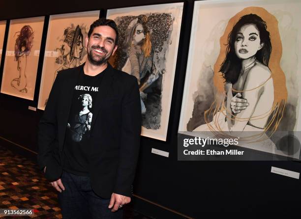 Hard Rock Hotel & Casino curator Beau Dobney poses in front of a display of fine art giclee prints by singer Brandon Boyd of Incubus outside The...