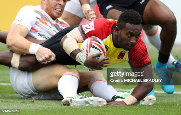 Paupa New Guinea's Wesley Vali is held up short of the try line by Englnad's James Rodwell during the World Rugby Sevens Series match between Paupa...