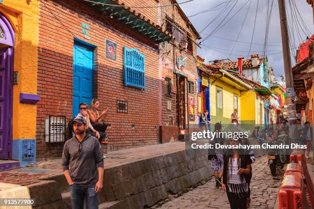 bogotá, colombia - local colombianos en la adoquinada calle del embudo, en el histórico barrio de candelaria de la capital andina - calle del embudo fotografías e imágenes de stock