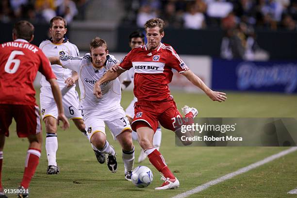 Brian McBride of the Chicago Fire controls the ball past Chris Birchall of the Los Angeles Galaxy during their MLS game at The Home Depot Center on...