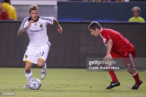 David Beckham of the Los Angeles Galaxy attacks Logan Pause of the Chicago Fire during their MLS game at The Home Depot Center on October 2, 2009 in...