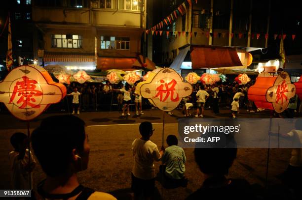 Children hold lanterns as they patricipate in the annual Fire Dragon Dance at the opening of the Mid-Autumn Festival in Tai Hang in Causeway Bay,...