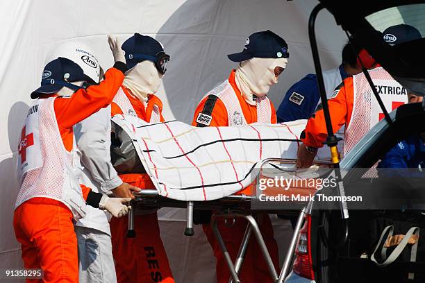 Timo Glock of Germany and Toyota is stretchered away by medical staff and marshalls after crashing during qualifying for the Japanese Formula One...