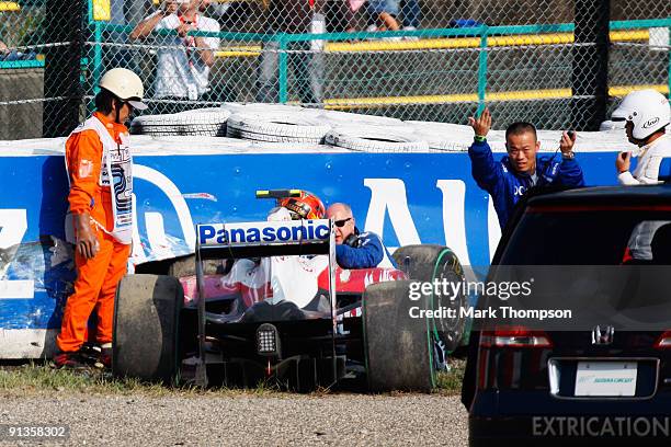Timo Glock of Germany and Toyota is attended to by medical staff and marshalls after crashing during qualifying for the Japanese Formula One Grand...