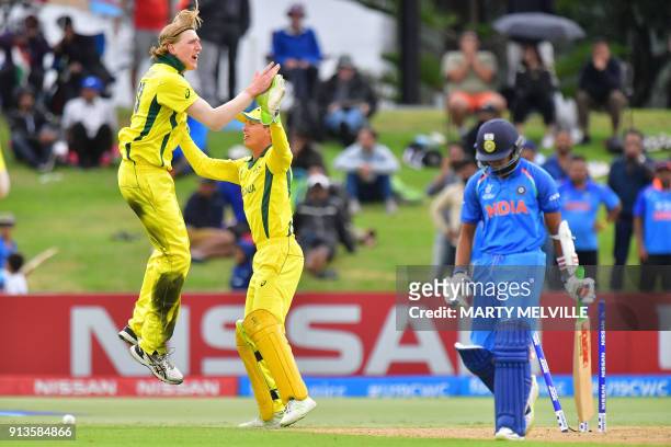 Australia's Will Sutherland celebrates with wicketkeeper Baxter Holt after India's Prithvi Shaw was bowled out during the U19 cricket World Cup final...