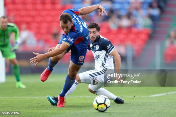 Ben Kantarovski of the Jets contests the ball with Christian Theoharous of the Victory during the round 19 A-League match between the Newcastle Jets...