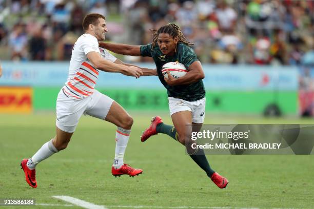 South Africa's Justin Geduld looks to fend off the tackle from England's Oliver Lindsay-Hague during the World Rugby Sevens Series match between...