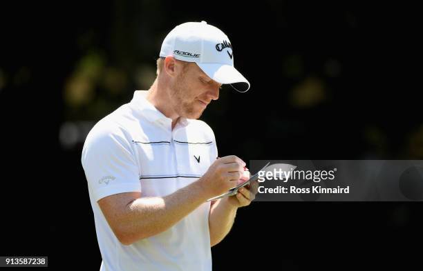David Horsey of England marks his score down on the 15th green during the third round of the Maybank Championship Malaysia at Saujana Golf and...