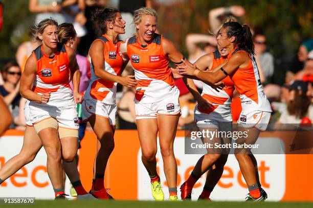 Phoebe McWilliams of the Giants is congratulated by her teammates after kicking a goal during the round one AFLW match between the Melbourne Demons...